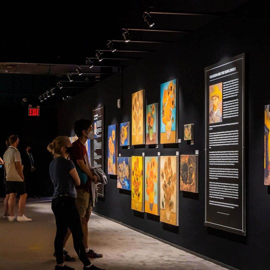 People looking at Sunflower paintings - Van Gogh Exhibit